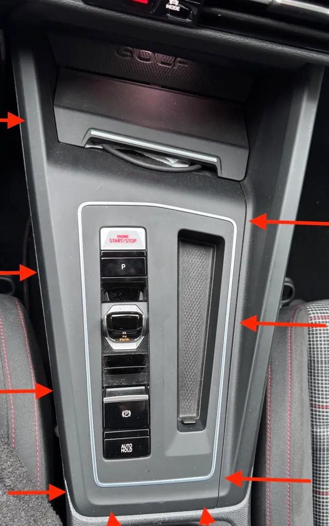 Centre console panel with pry points marked around the perimeter