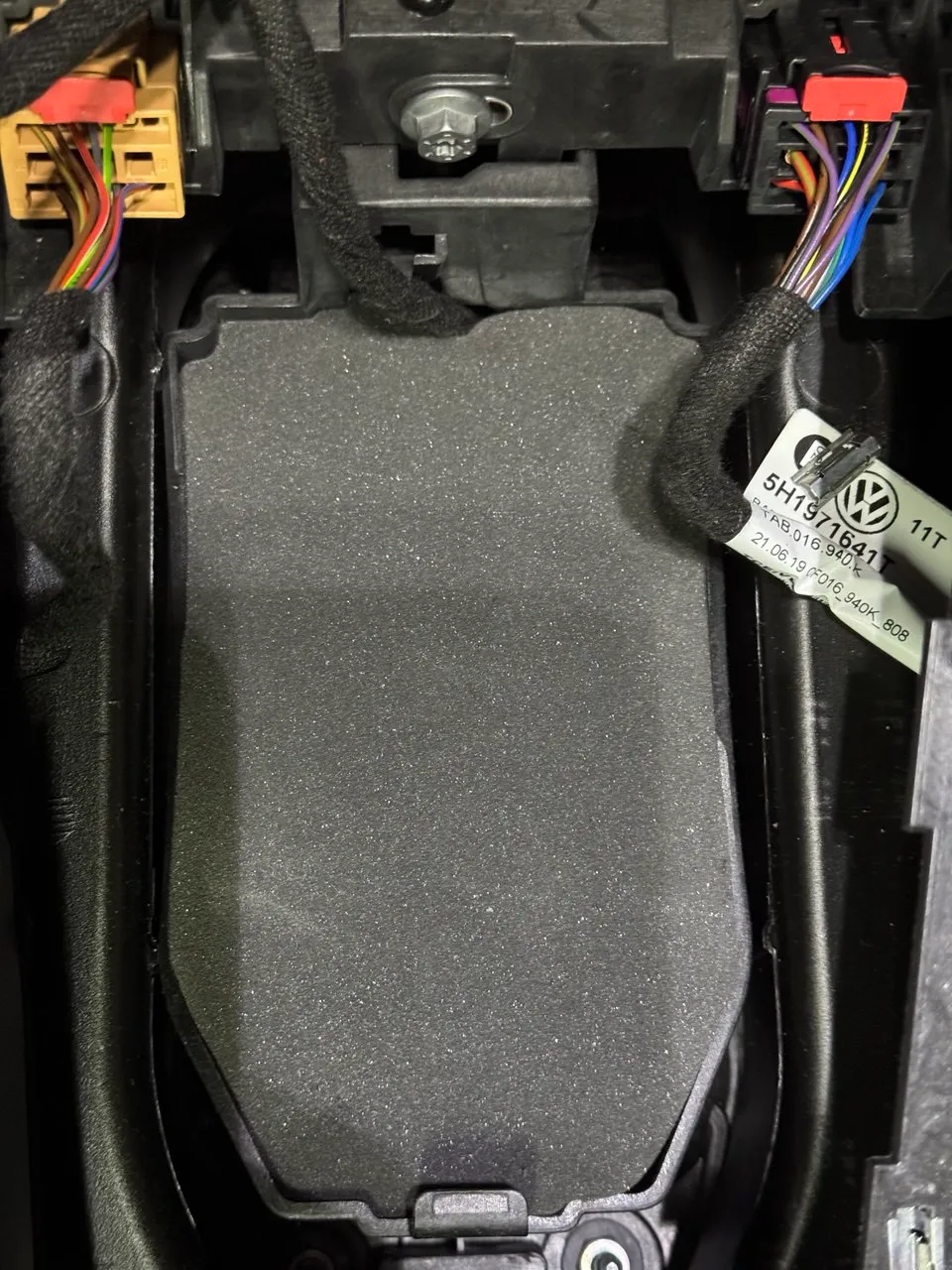 Centre console panel removed, foam padding lifted to expose the solenoid housing